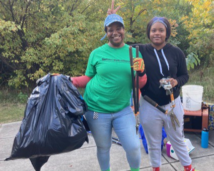 Environmental students with bags of debris and cleanup tools