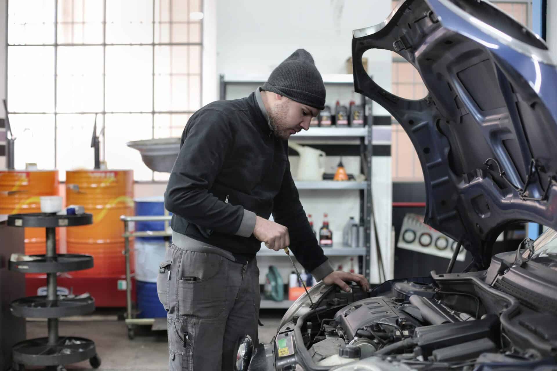 man checking the oil of a car