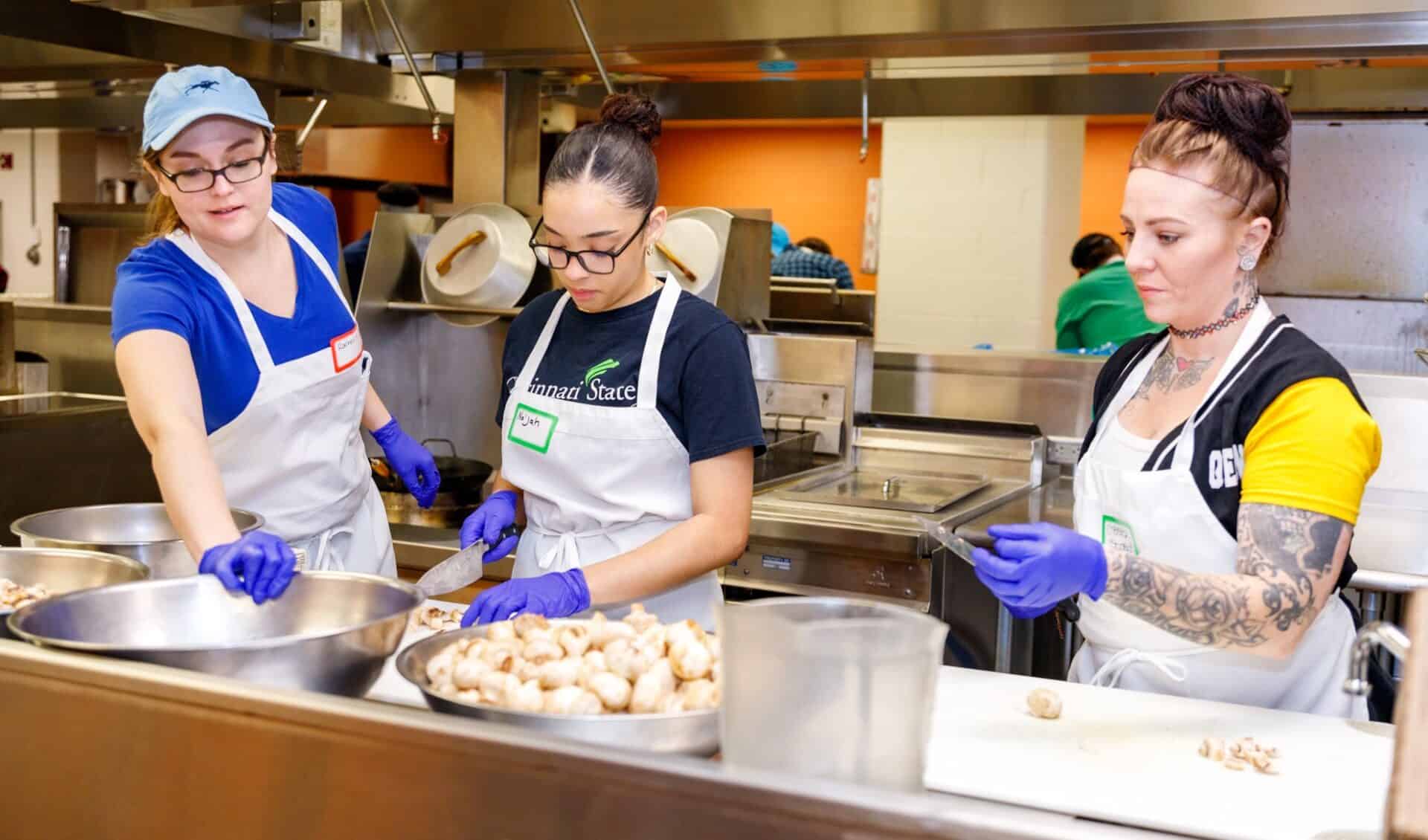 Students Rachel Scheidt, Na’Jah Lott and Chelsea Kiskaden working in the kitchen
