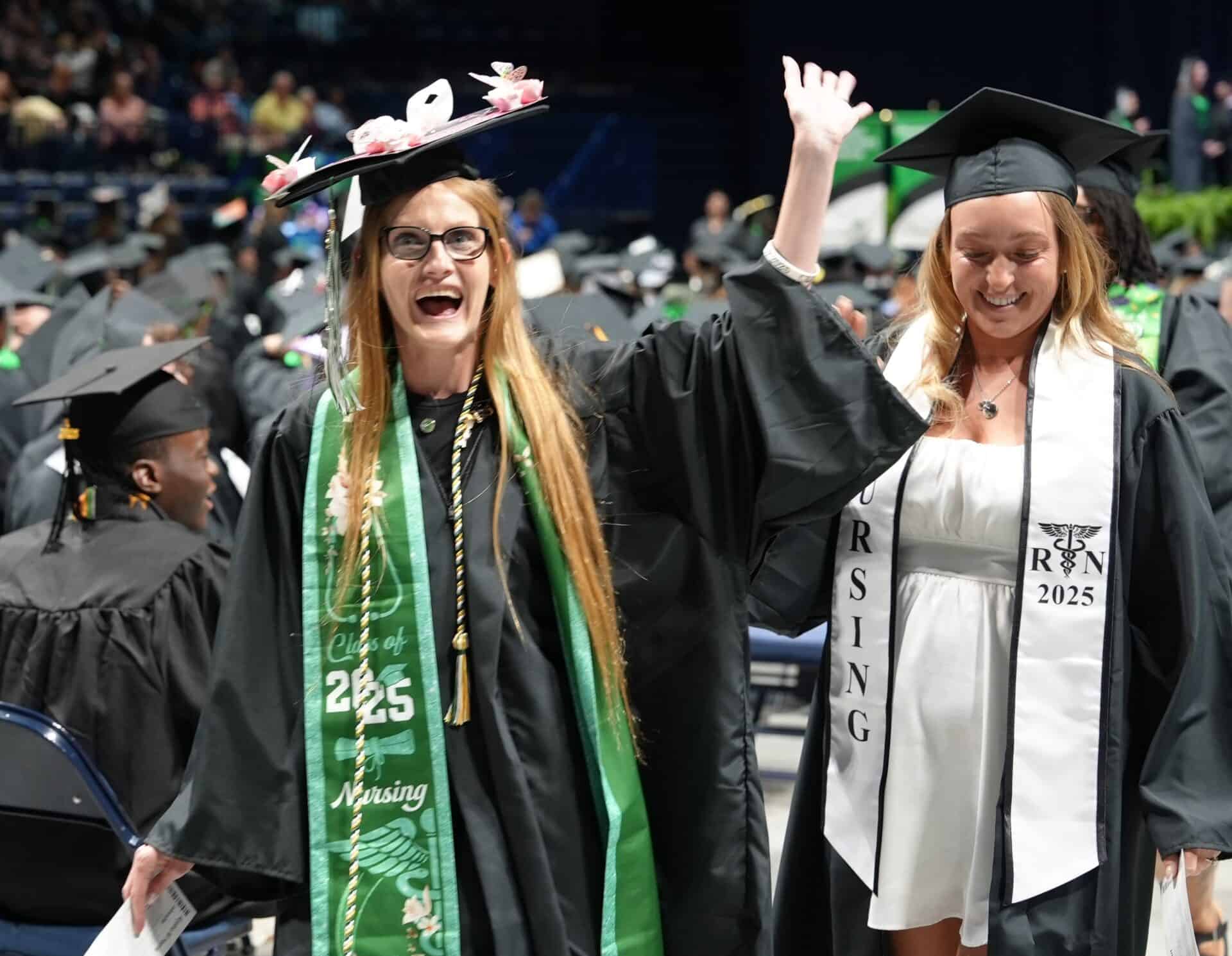 Female graduate waving to the crowd at Commencement