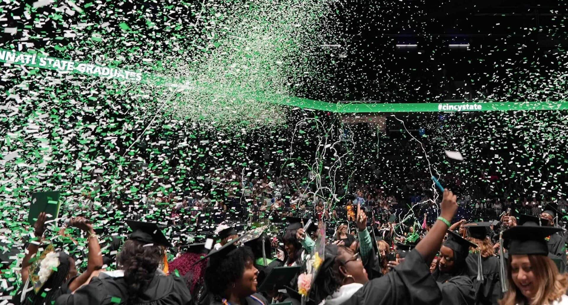 Graduates celebrating as confetti falls at Commencement