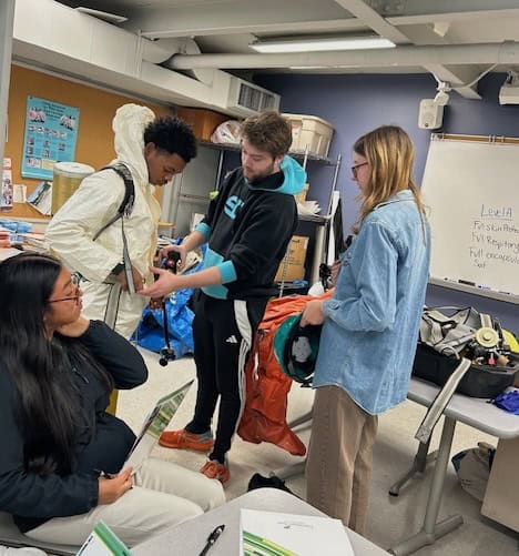 Trying on OSHA safety gear at HS Environmental Day - Nov. 2025