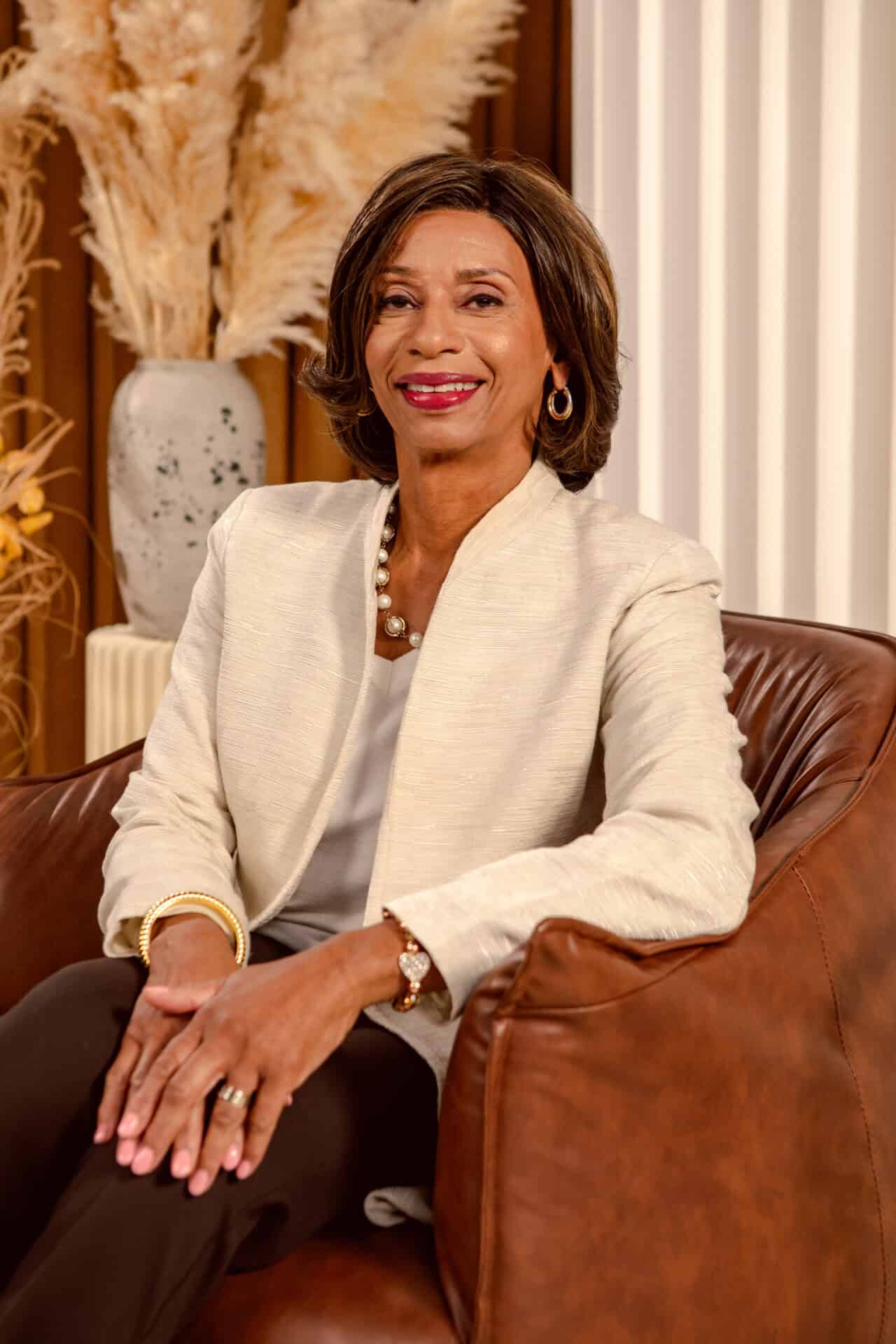 Dr. Monica Posey, President of Cincinnati State, seated in a tan chair wearing a white blazer with her hands on her lap