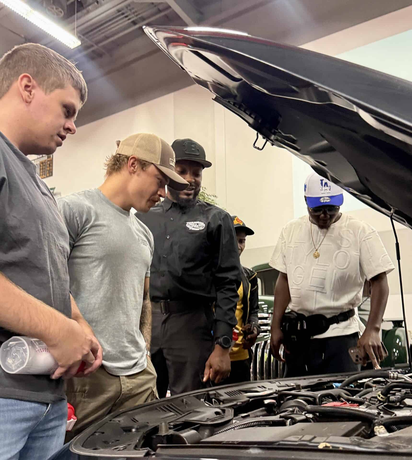 Automotive students looking under the hood of their new car